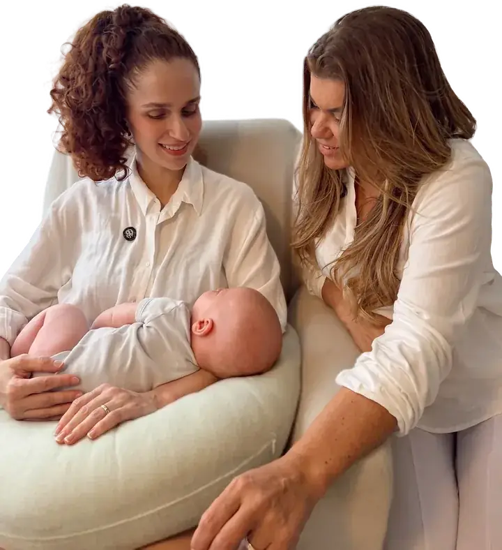 Consultora de amamentação orientando mãe com seu bebê sobre a almofada de amamentação